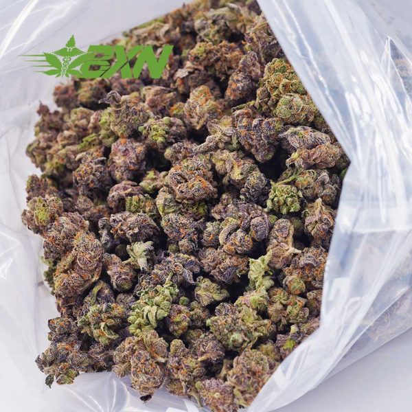 A bag of green and purple marijuana flowers buds